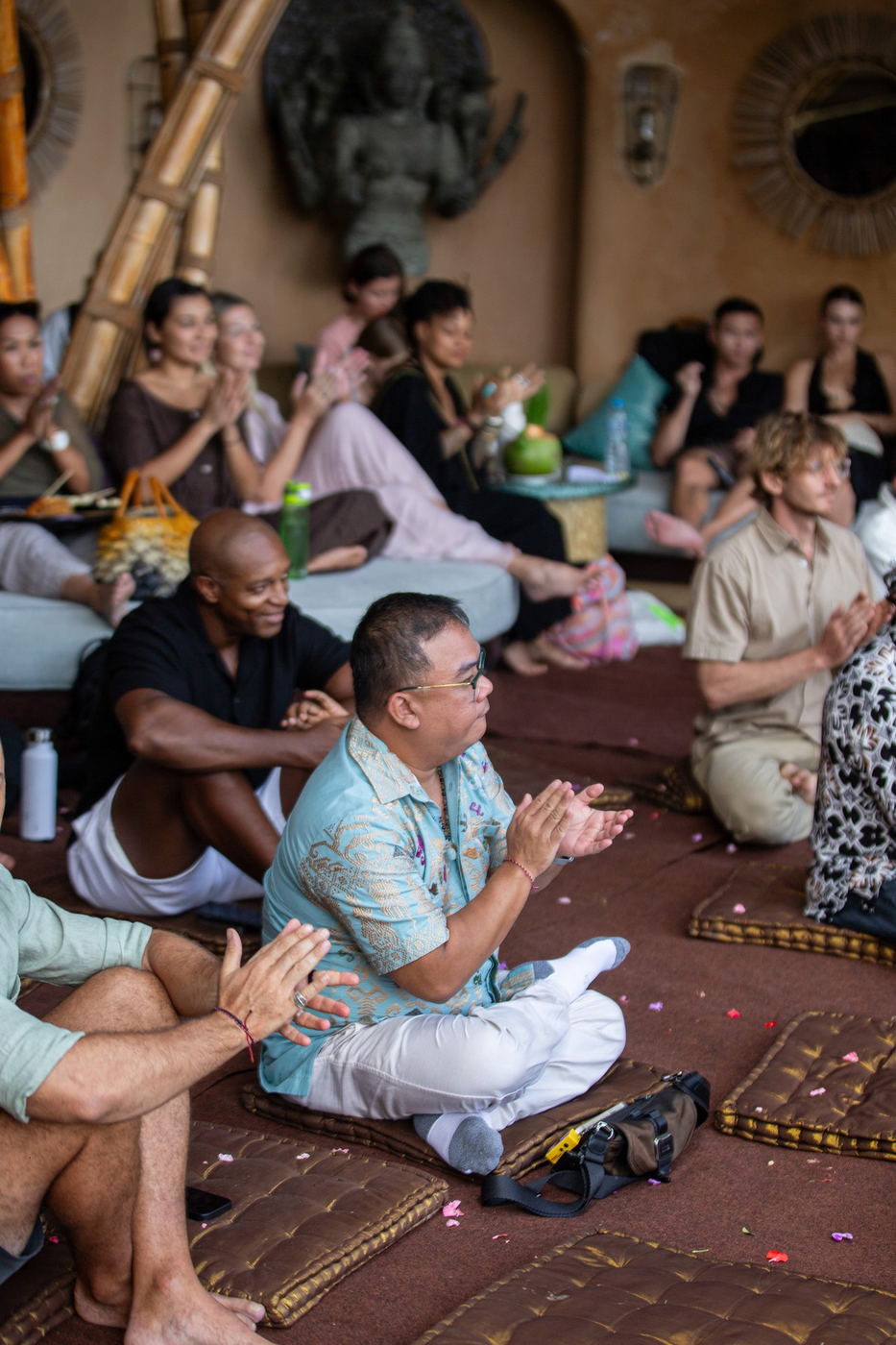 Audience clapping, seated on floor cushions at Akasha