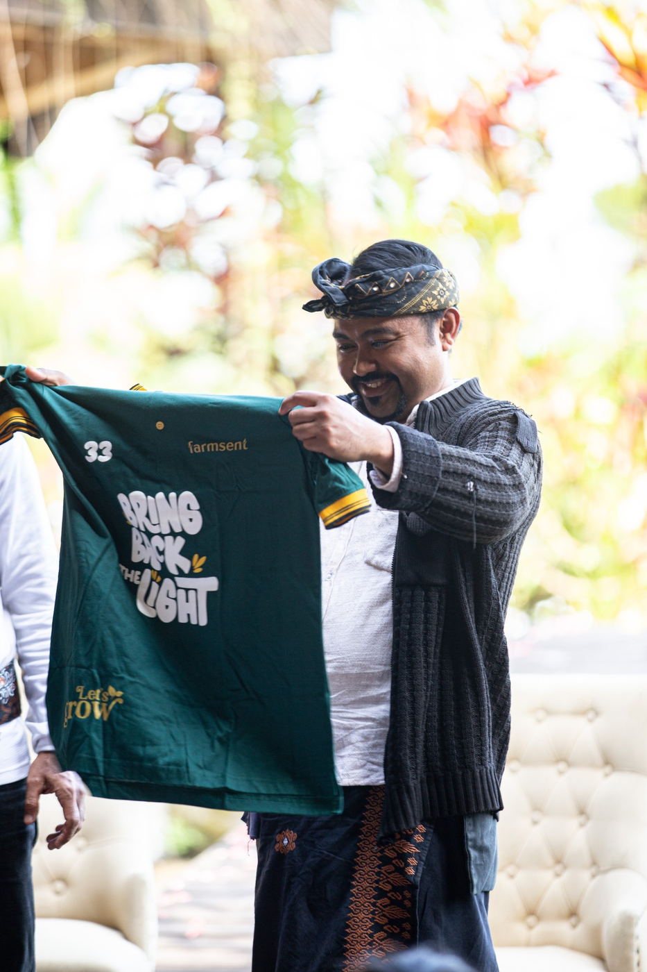 Wayan Wardika holding a Bring Back The Light shirt