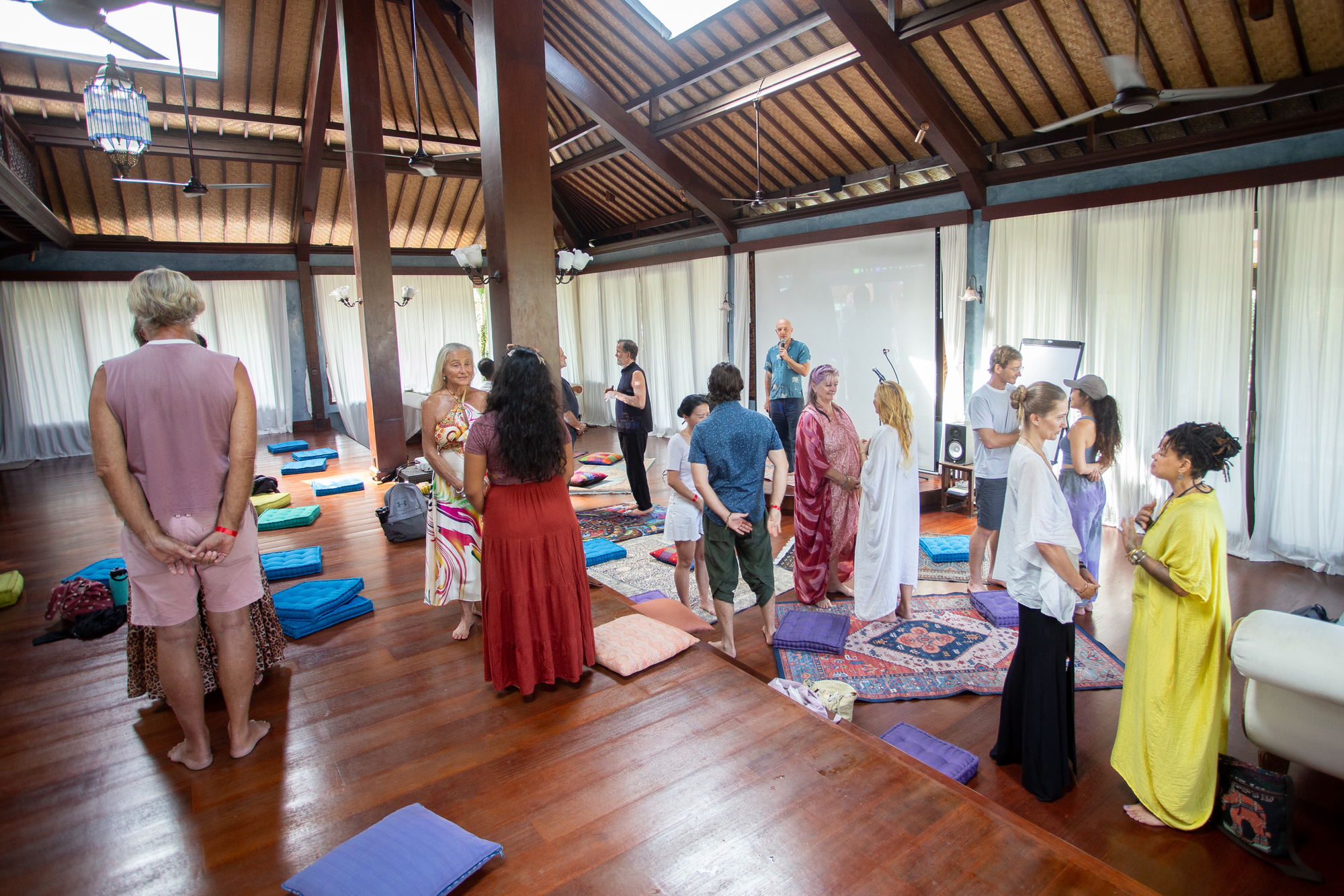 Participants standing in a wide circle on the pavilion floor