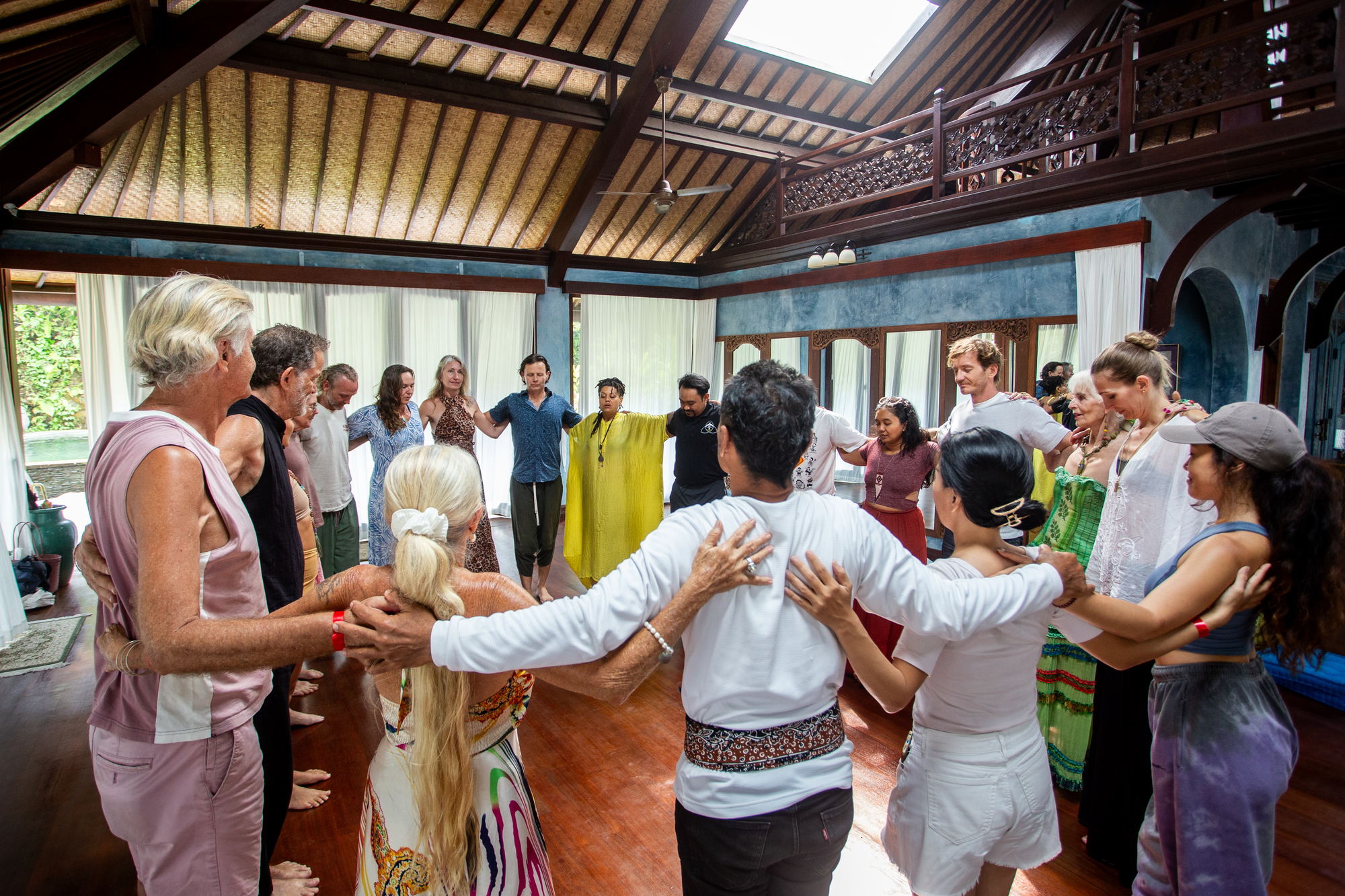 Circle of participants standing with arms around one another at Bhakti Marga