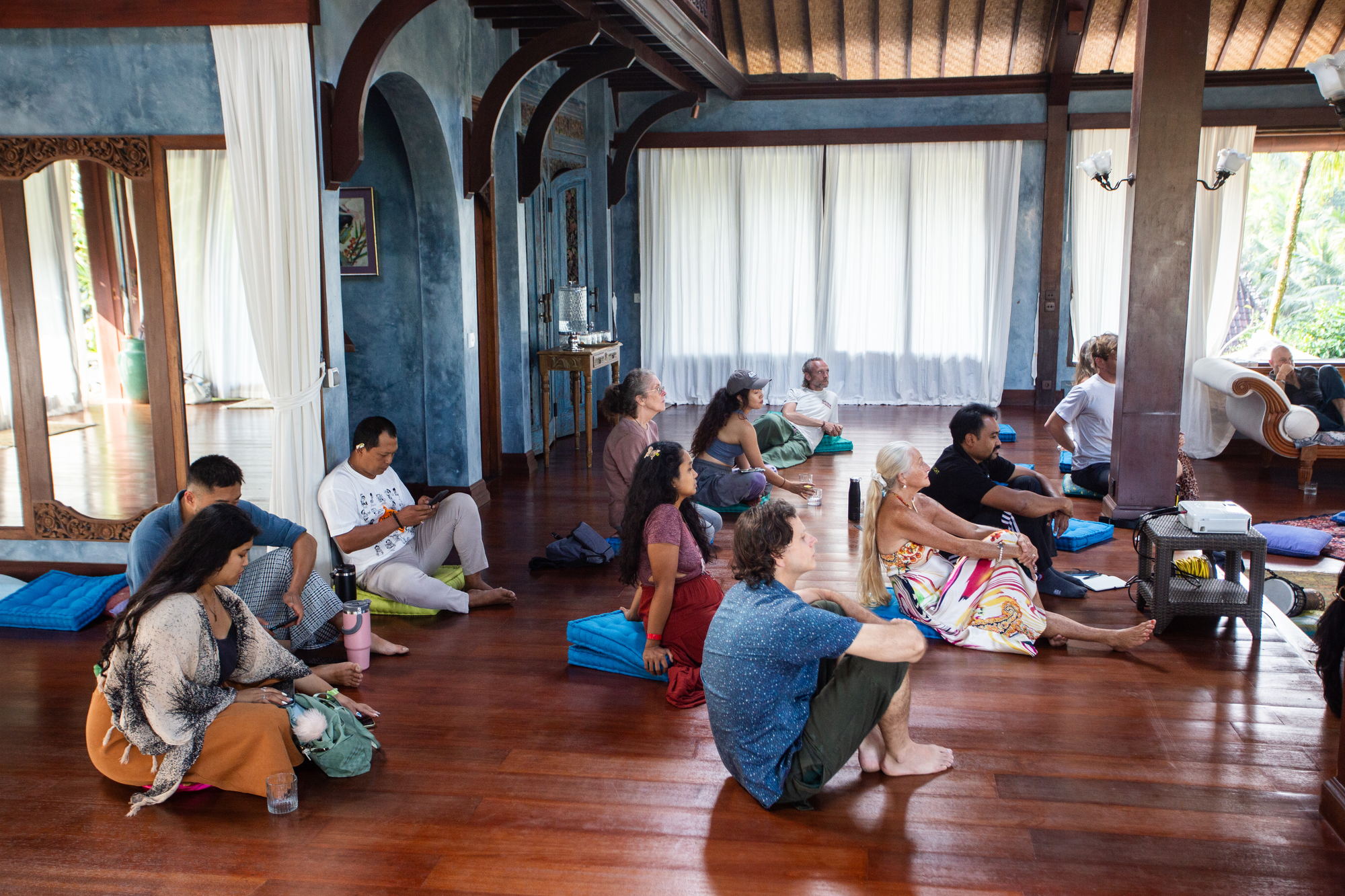 The group seated on cushions, seen from behind