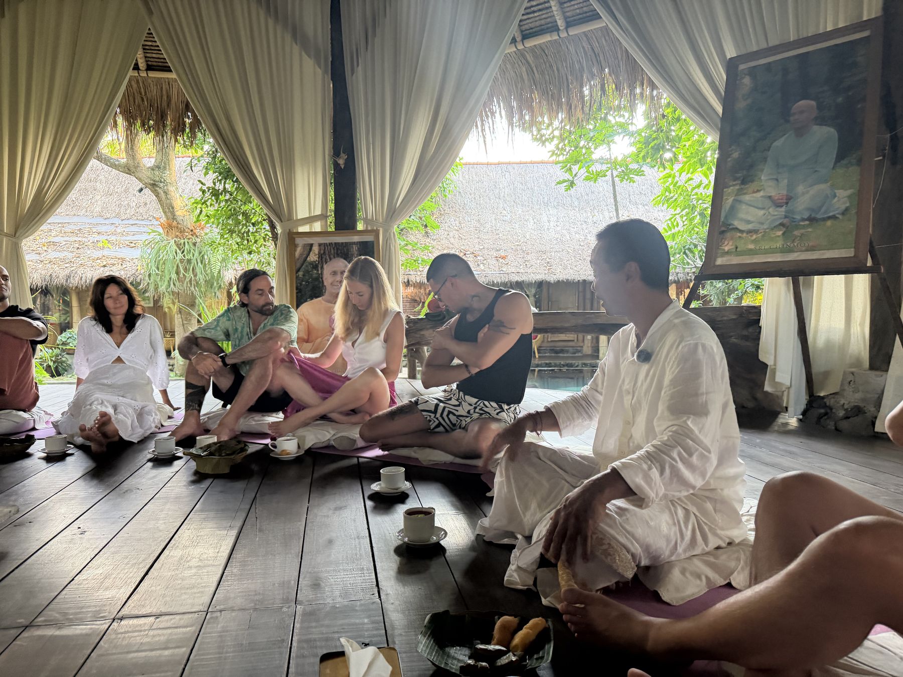 Visiting practitioners sitting in circle on the open pavilion floor