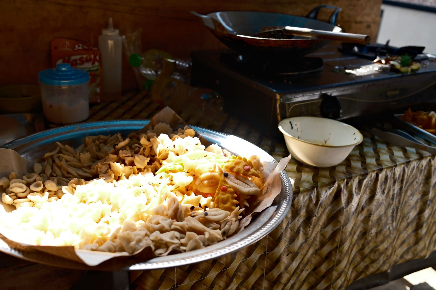 Crackers laid out on a tray beside the wok and burner