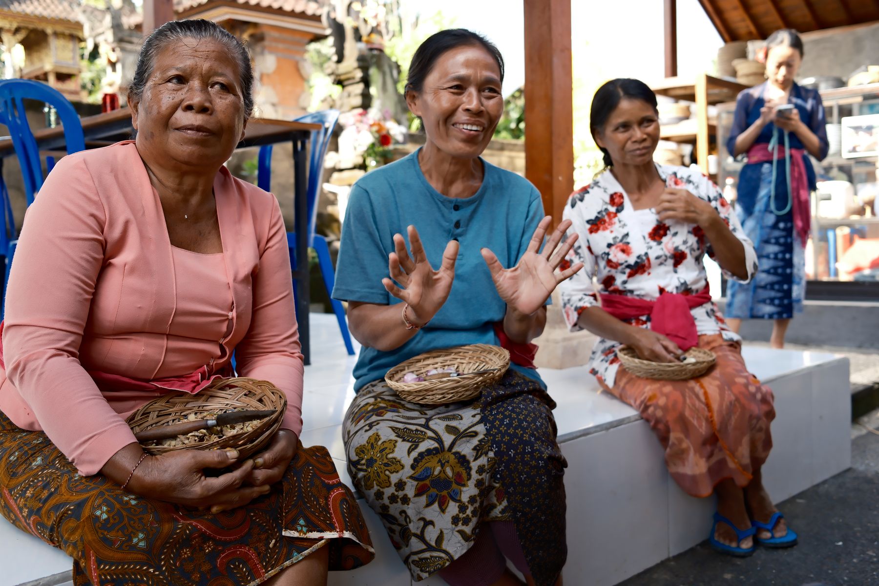 A spice maker describing the work while two others listen