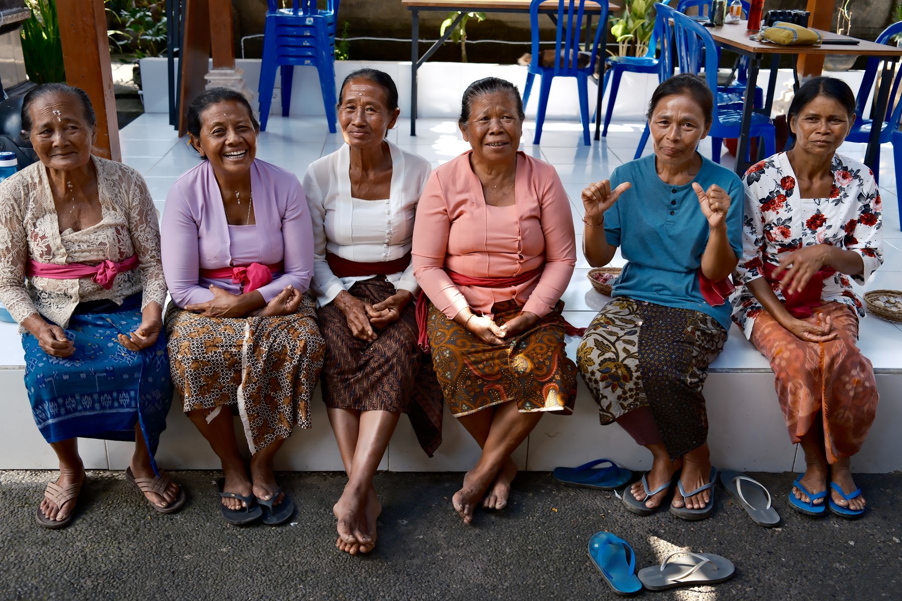Six spice makers seated together in a row after a morning's work